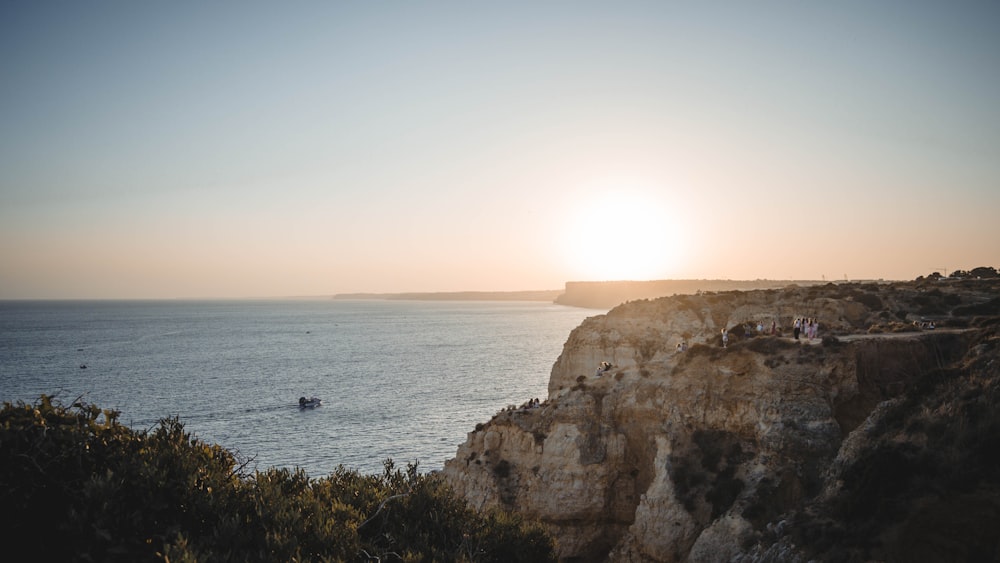 a body of water with a rocky shoreline and a sunny sky