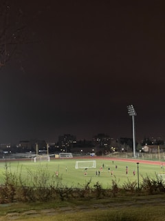 Night scene of an illuminated soccer field with players in action