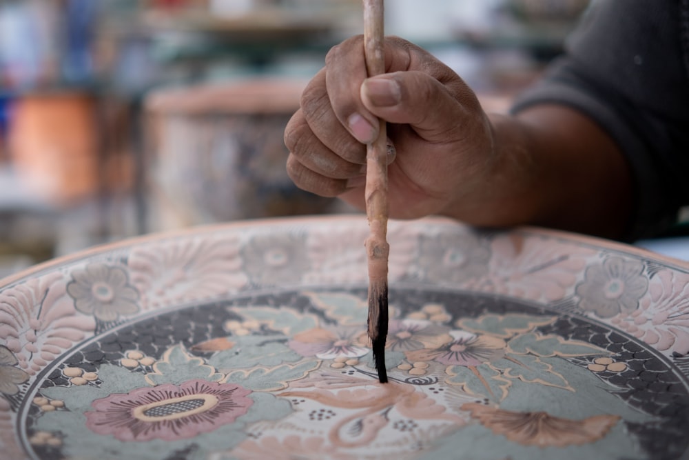 a hand holding a pencil over a map