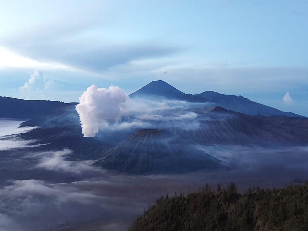 a mountain range with clouds below