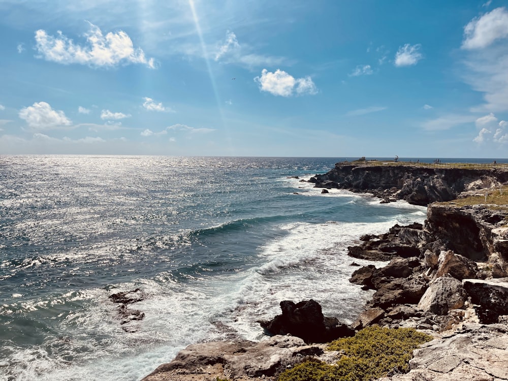 a rocky beach with waves crashing against the shore