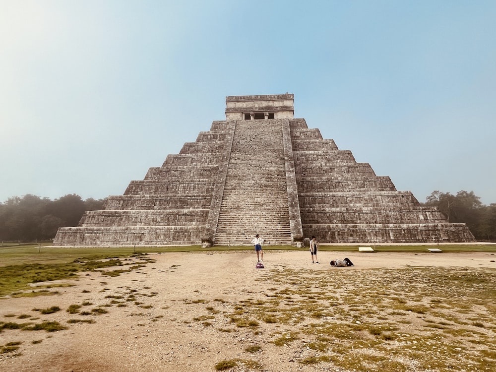 people walking towards a pyramid with Chichen Itza in the background