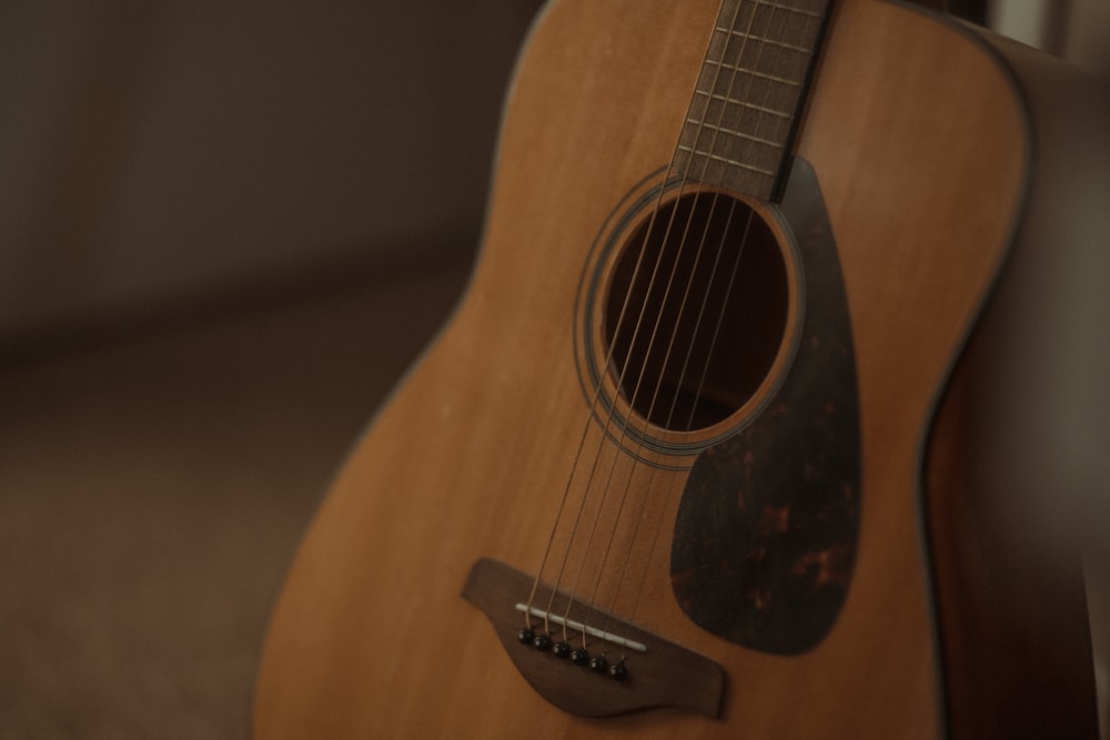 Una guitarra apoyada contra una pared