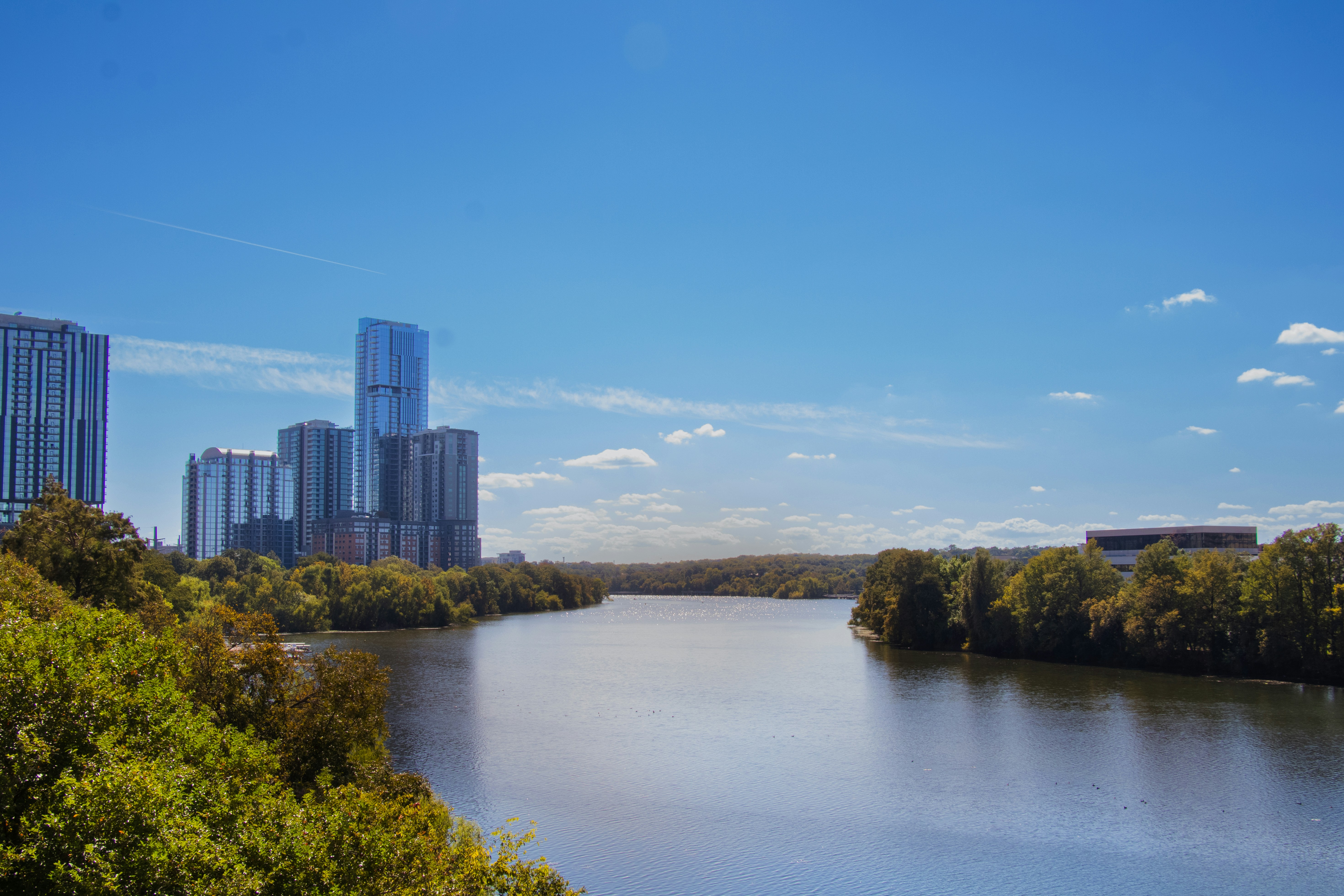 a body of water with trees and buildings around it, Colorado river, Austin, Texas