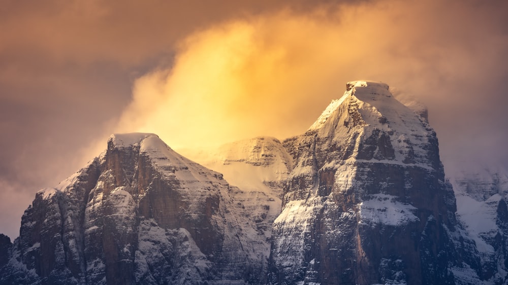 a snowy mountain with a yellow sky