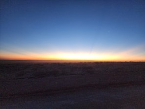 A panoramic view of the mini farm bathed in the soft pinks and oranges of sunset