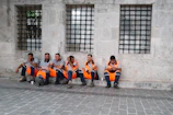 Operators wearing orange and yellow safety vests interacting during a break on the factory site.