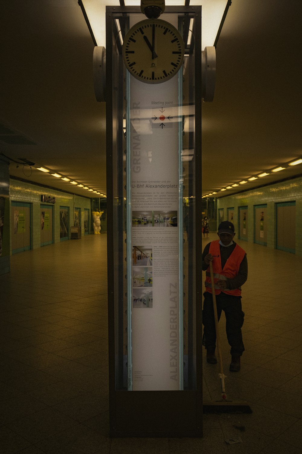 a person standing next to a clock