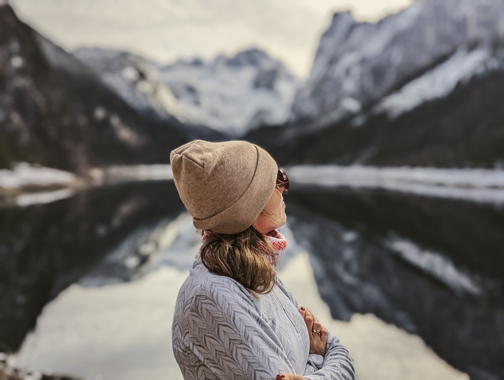 a person with a hat and a beard looking at a mountain