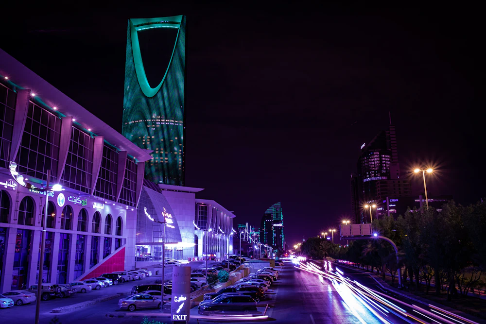 Riyadh street at night with the Kingdom Centre in the distance