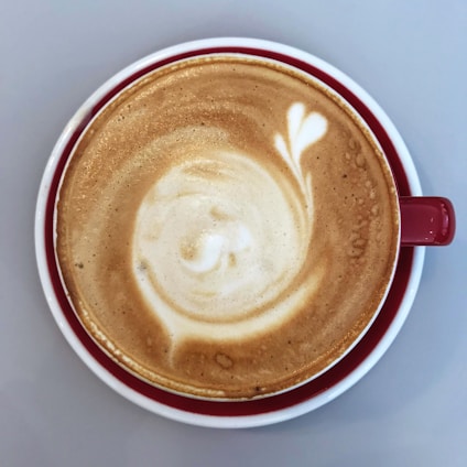 A close-up of a beautifully crafted coffee cup with latte art on a wooden table.
