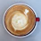 Close-up of a perfectly crafted cappuccino with delicate latte art in a sleek black cup.