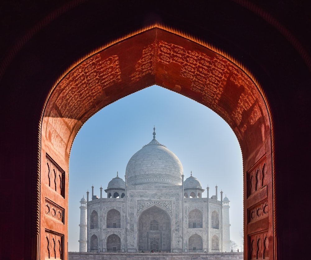 a large arched doorway with a domed building in the background