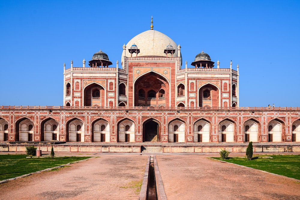 a large pink building with Humayun's Tomb in the background