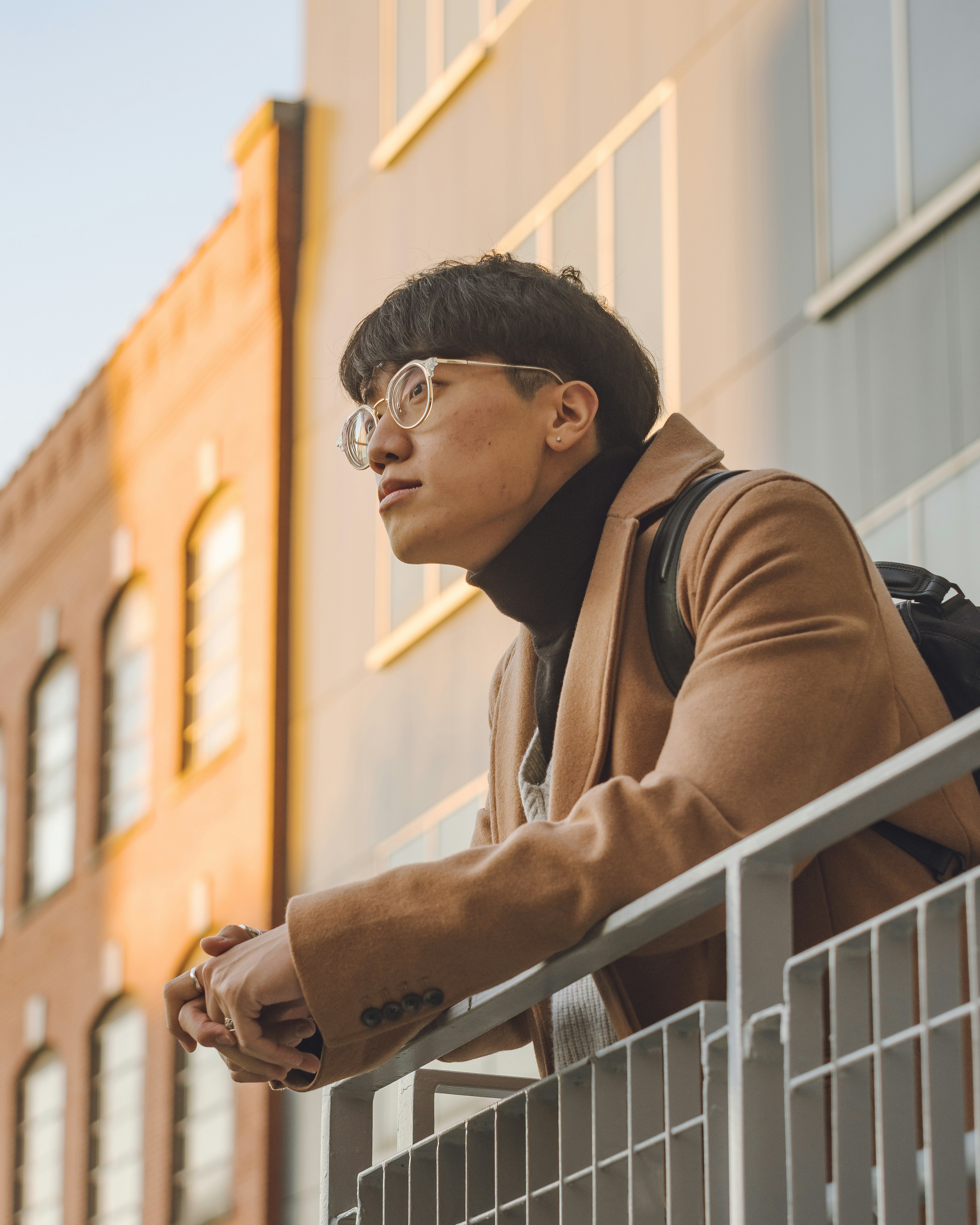 A man with glasses gazes toward the sunlight.