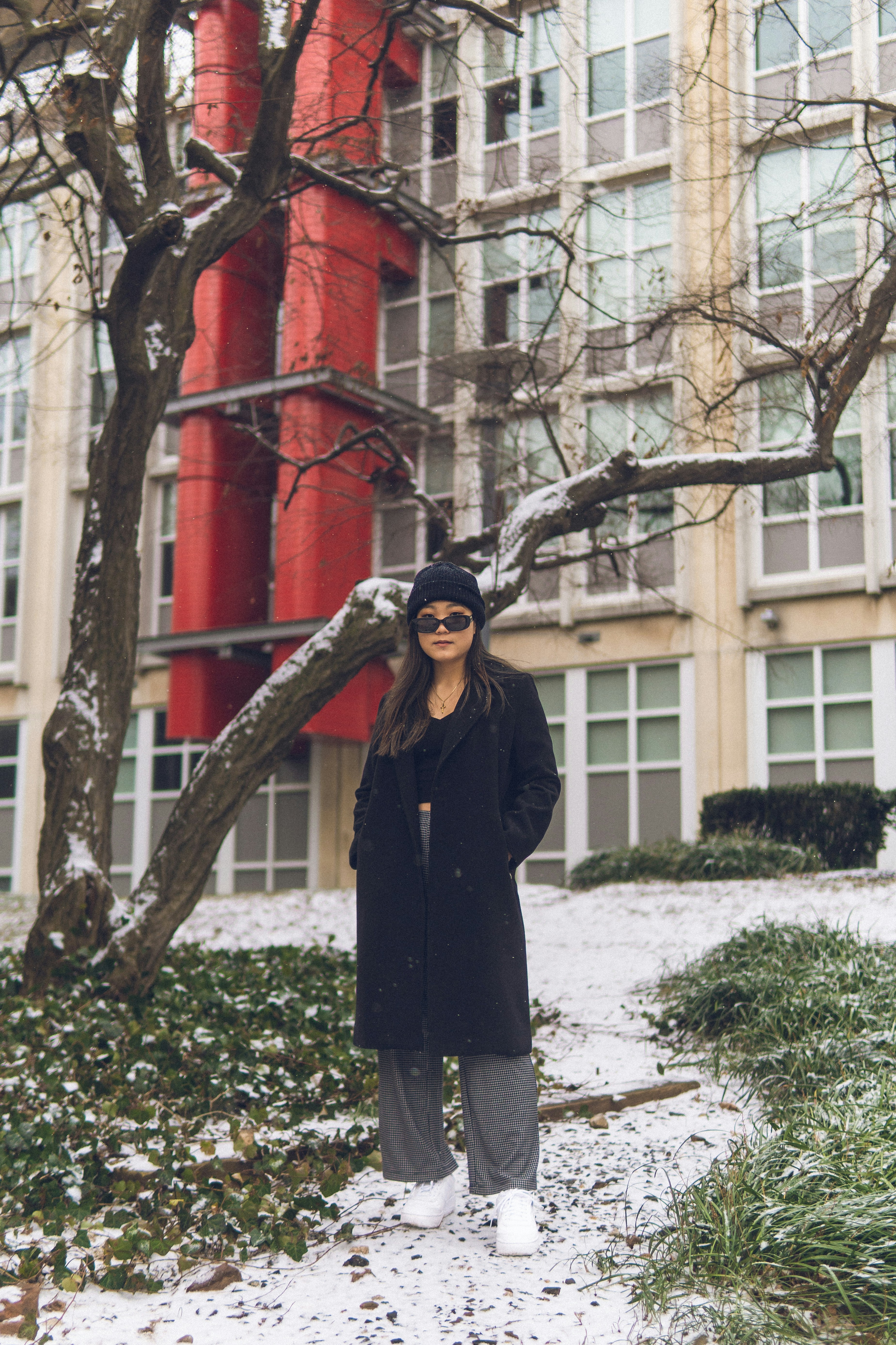 Woman poses in front of a building with snow.