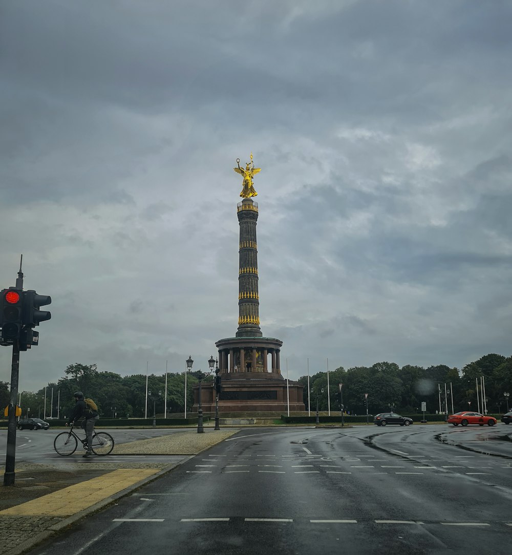 a tall tower with a gold top with Berlin Victory Column in the background