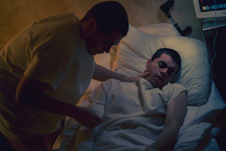 a man lying in a bed with a woman in a hospital bed