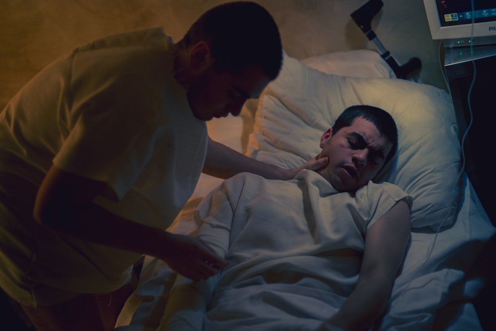 a man lying in a bed with a woman in a hospital bed