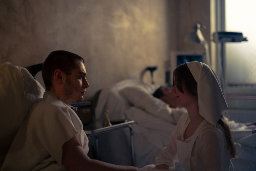 a man and woman sitting in a hospital bed