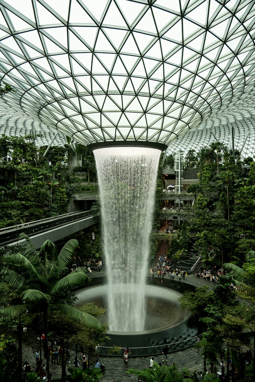 a large water fountain in a large indoor garden