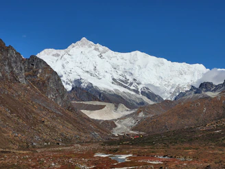 a snowy mountain with a river running through it