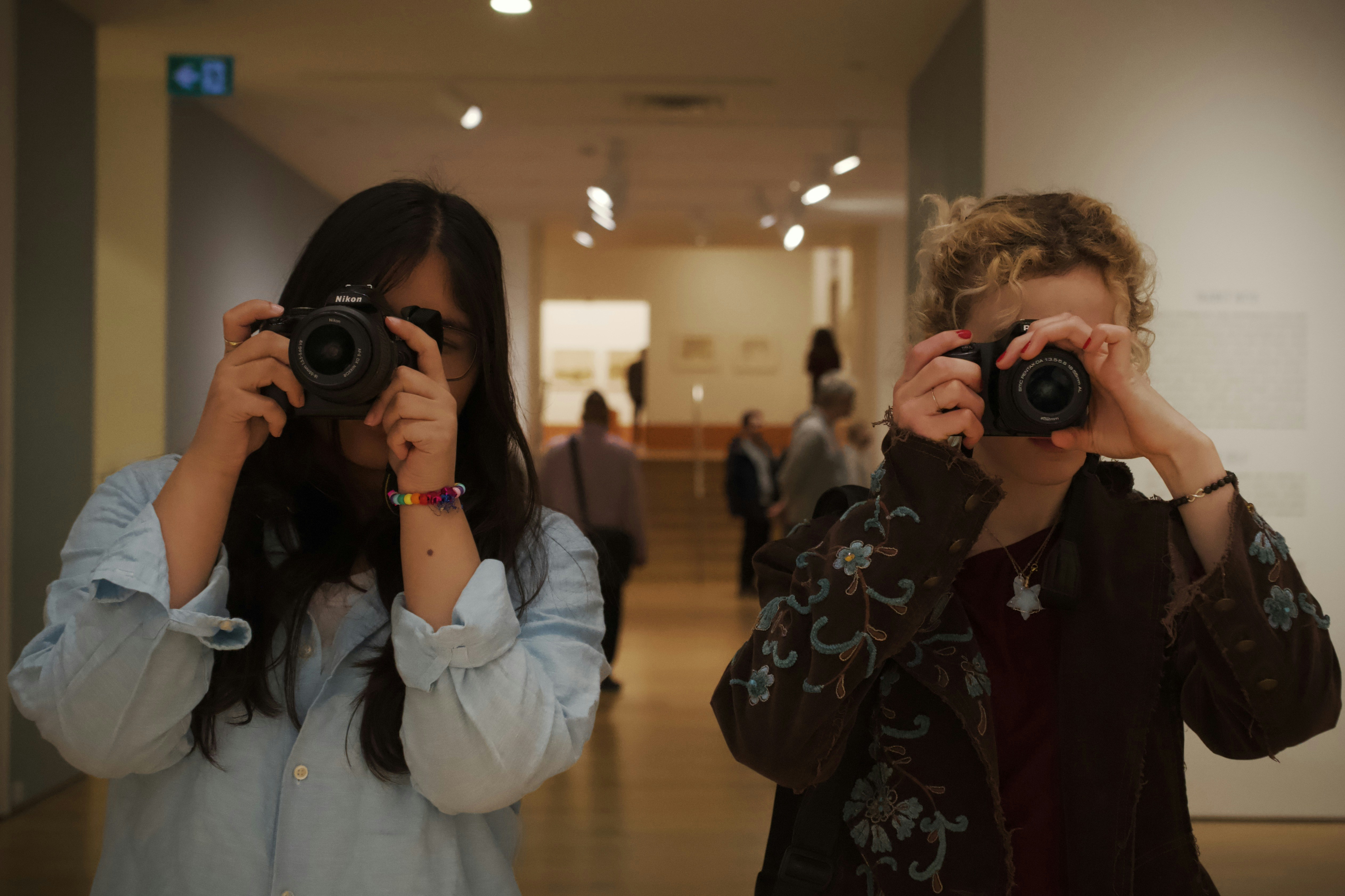 A person taking a picture of another woman with a camera photo – Free ...