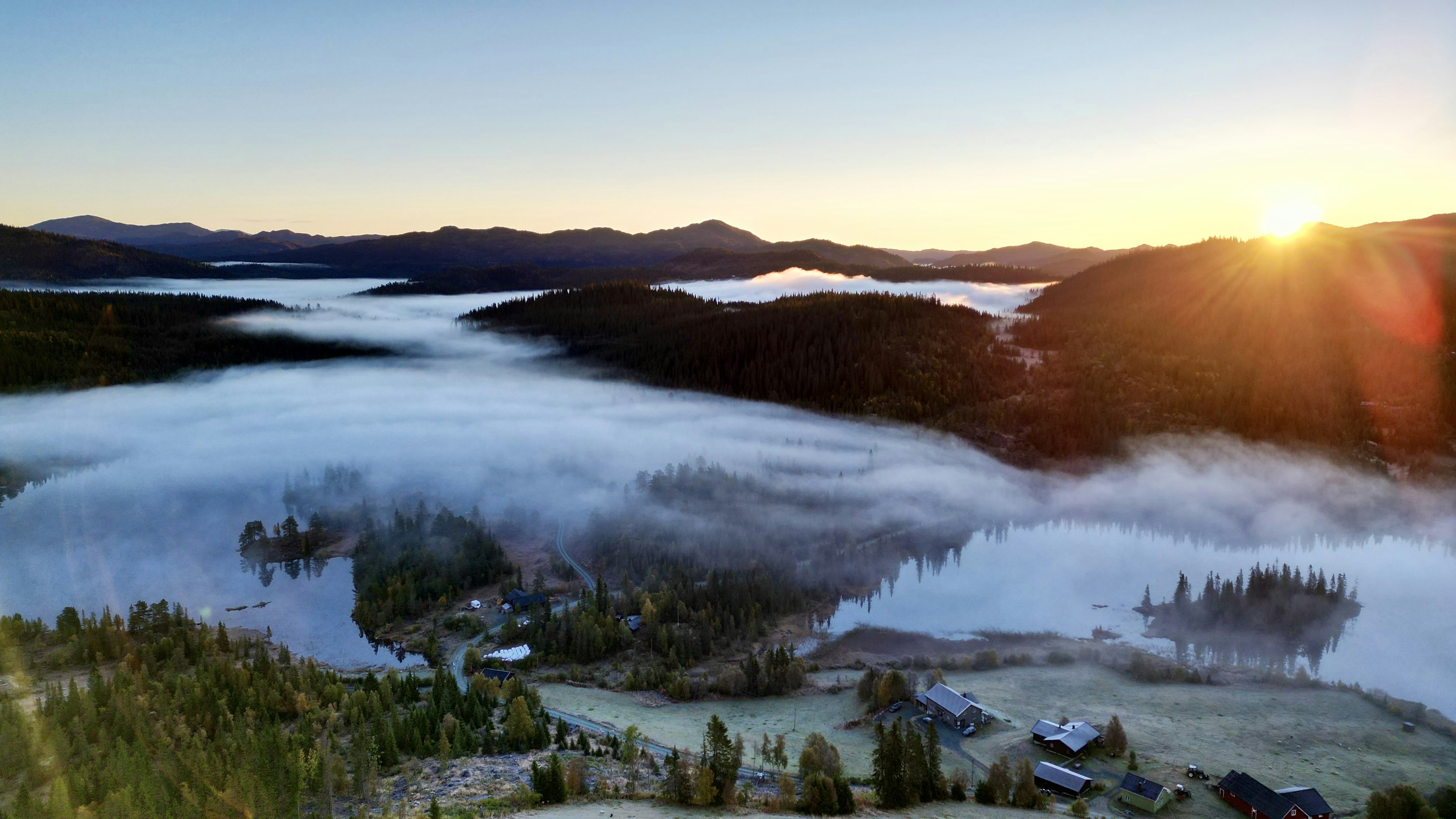 a river with a forest and a sunset