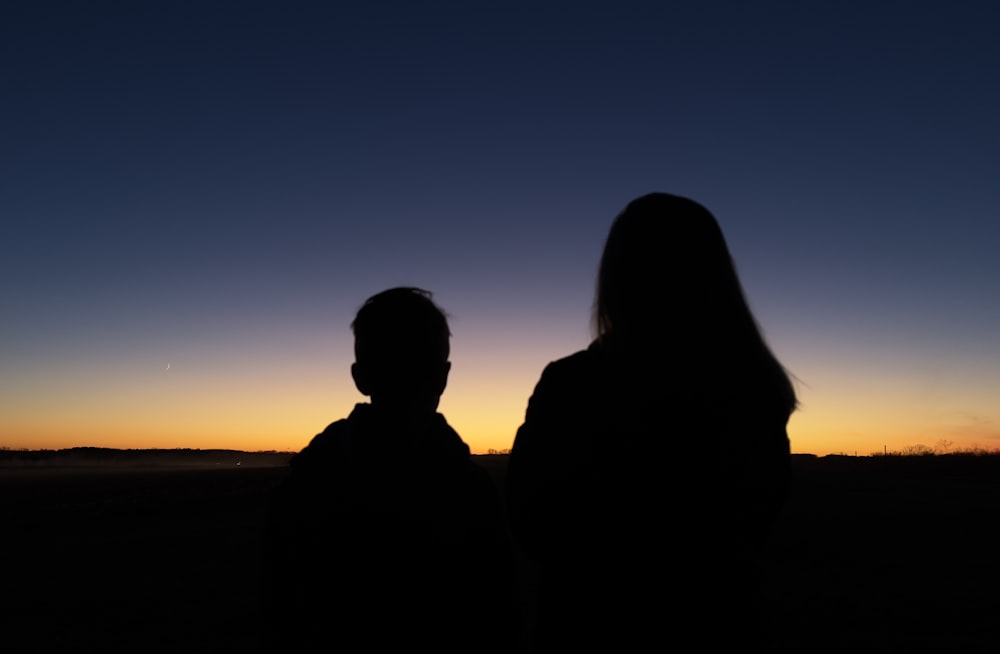 a couple of people looking at the sunset