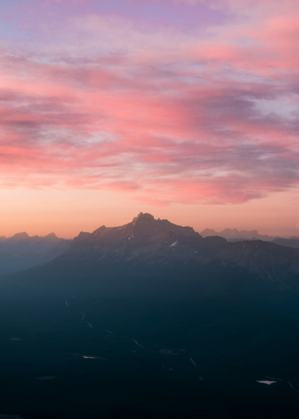 uma montanha com um céu rosa e roxo