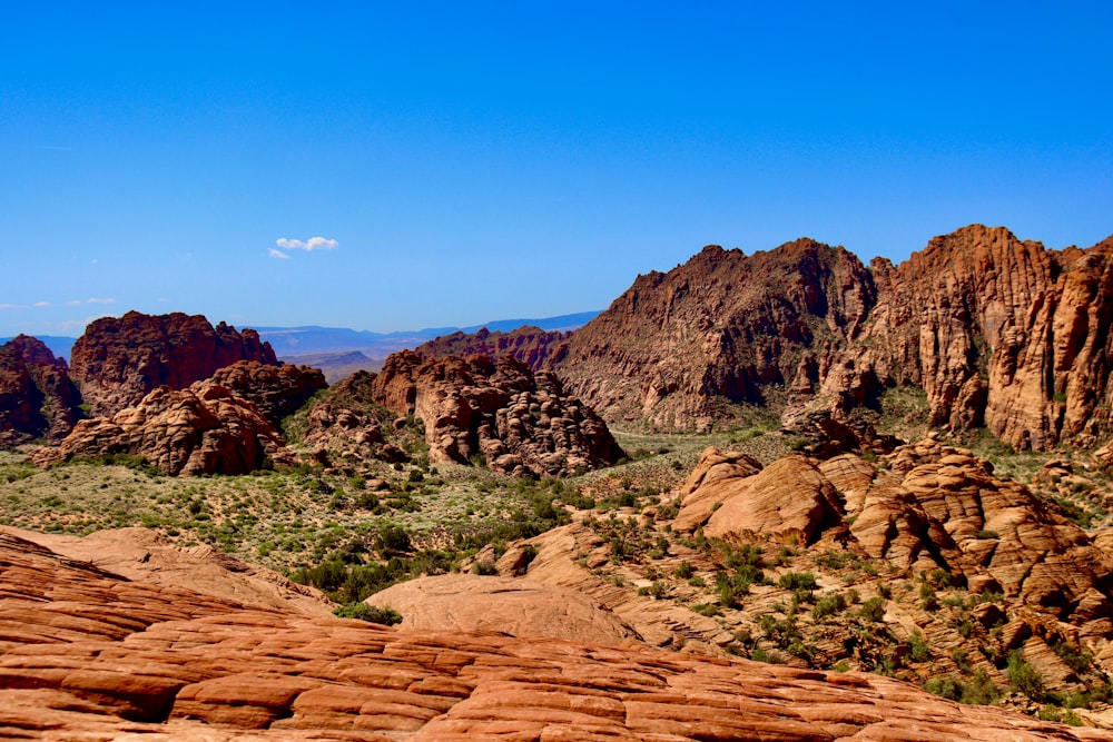 a rocky canyon with grass and blue sky