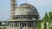Construction progress of Masjid Al Barakah showing workers and building materials.