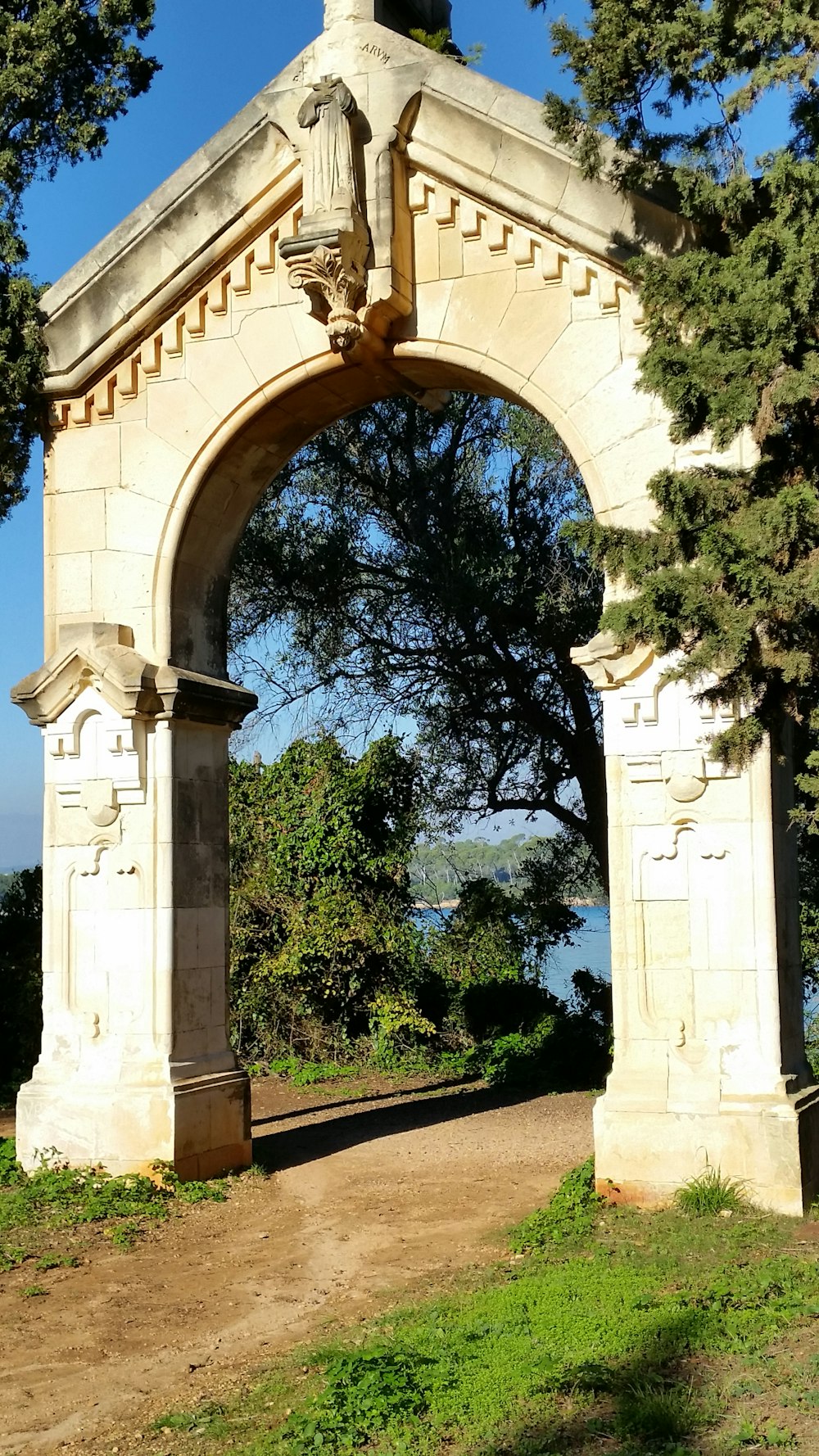 a stone archway with trees in the background