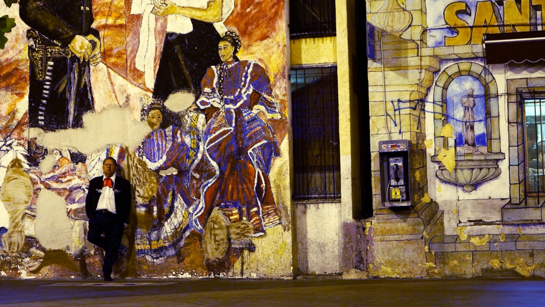 a person standing in front of a wall with art,