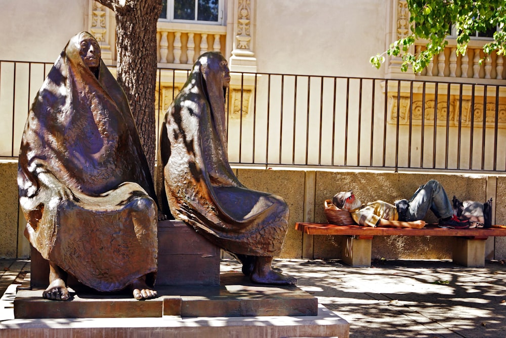 a group of statues of people sitting on the ground
