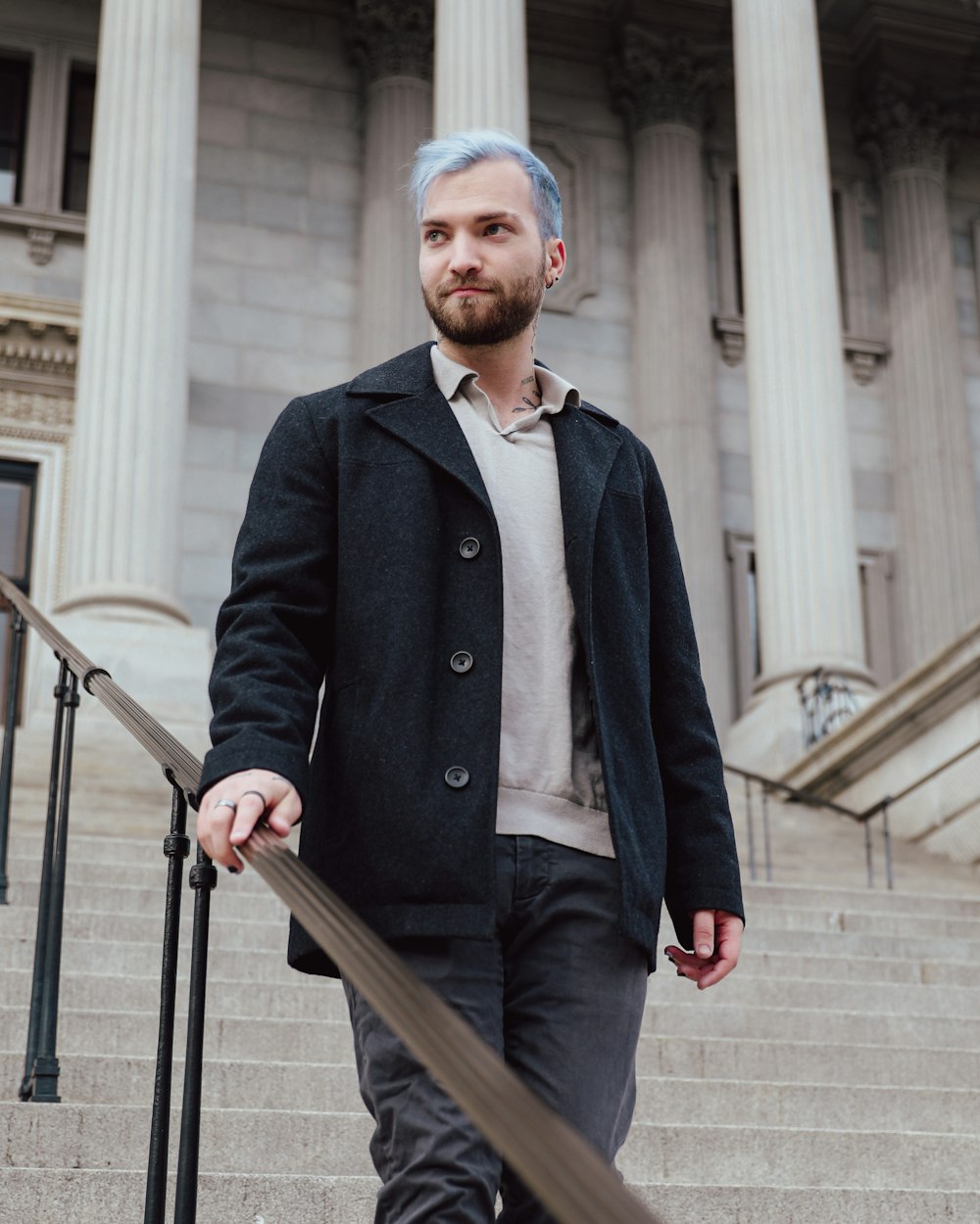 a man with blue hair and a beard standing on a staircase