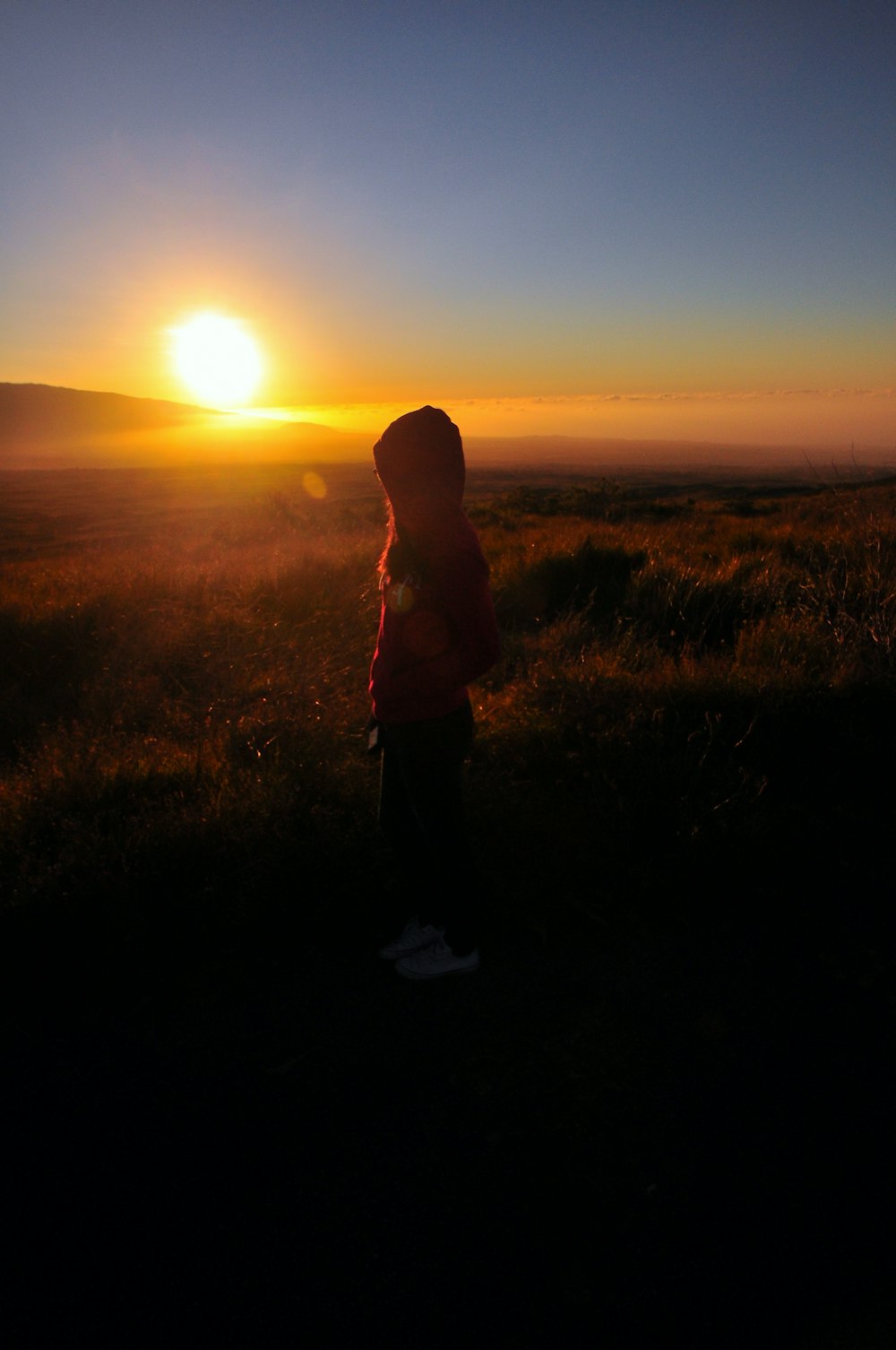 a person standing in front of a sunset