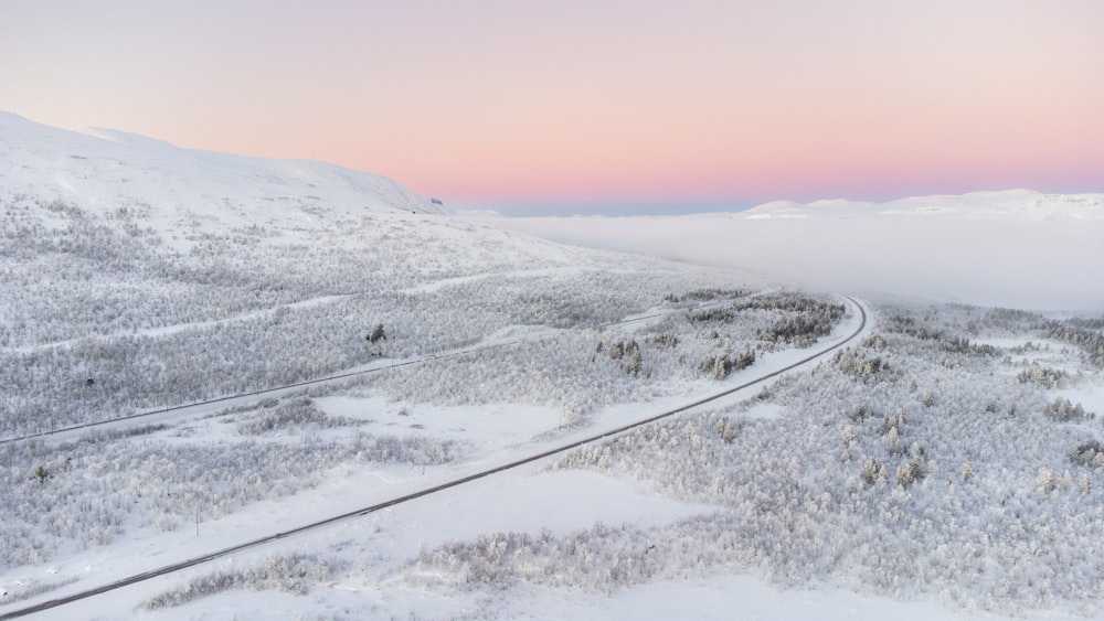 uma estrada em uma paisagem nevada