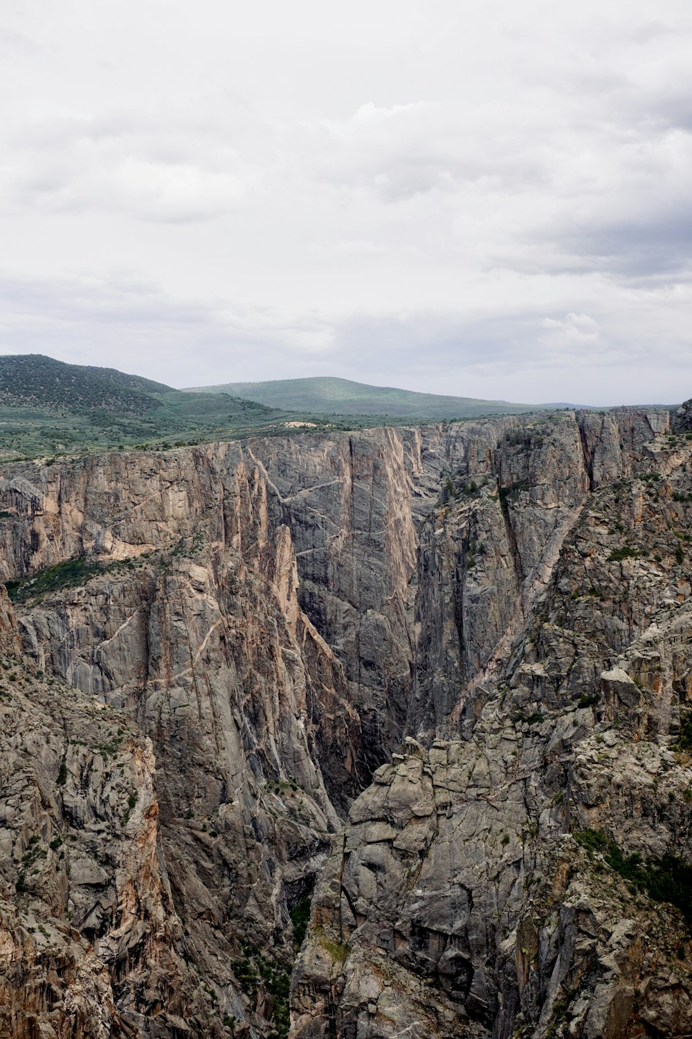 a rocky cliff with a valley below