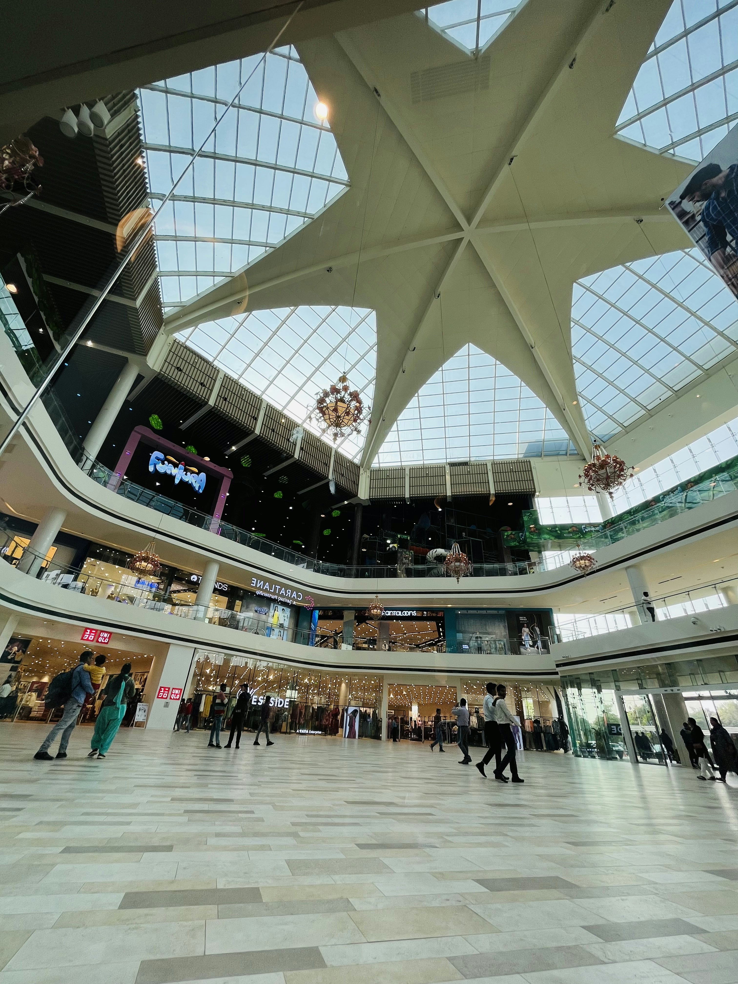 Modern upscale shopping mall interior with glass ceiling, luxury brand stores, and open walkways in Makati Philippines