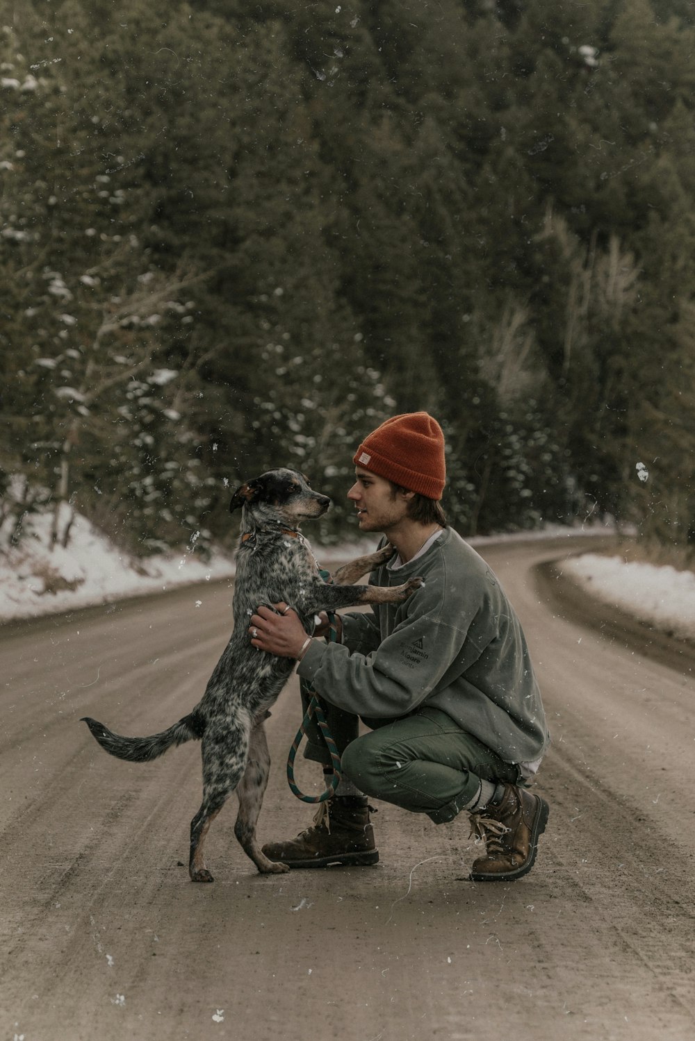 a man kneeling down holding a dog