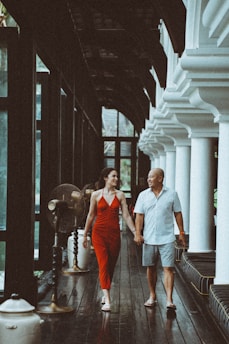 a man and woman walking down a wooden walkway