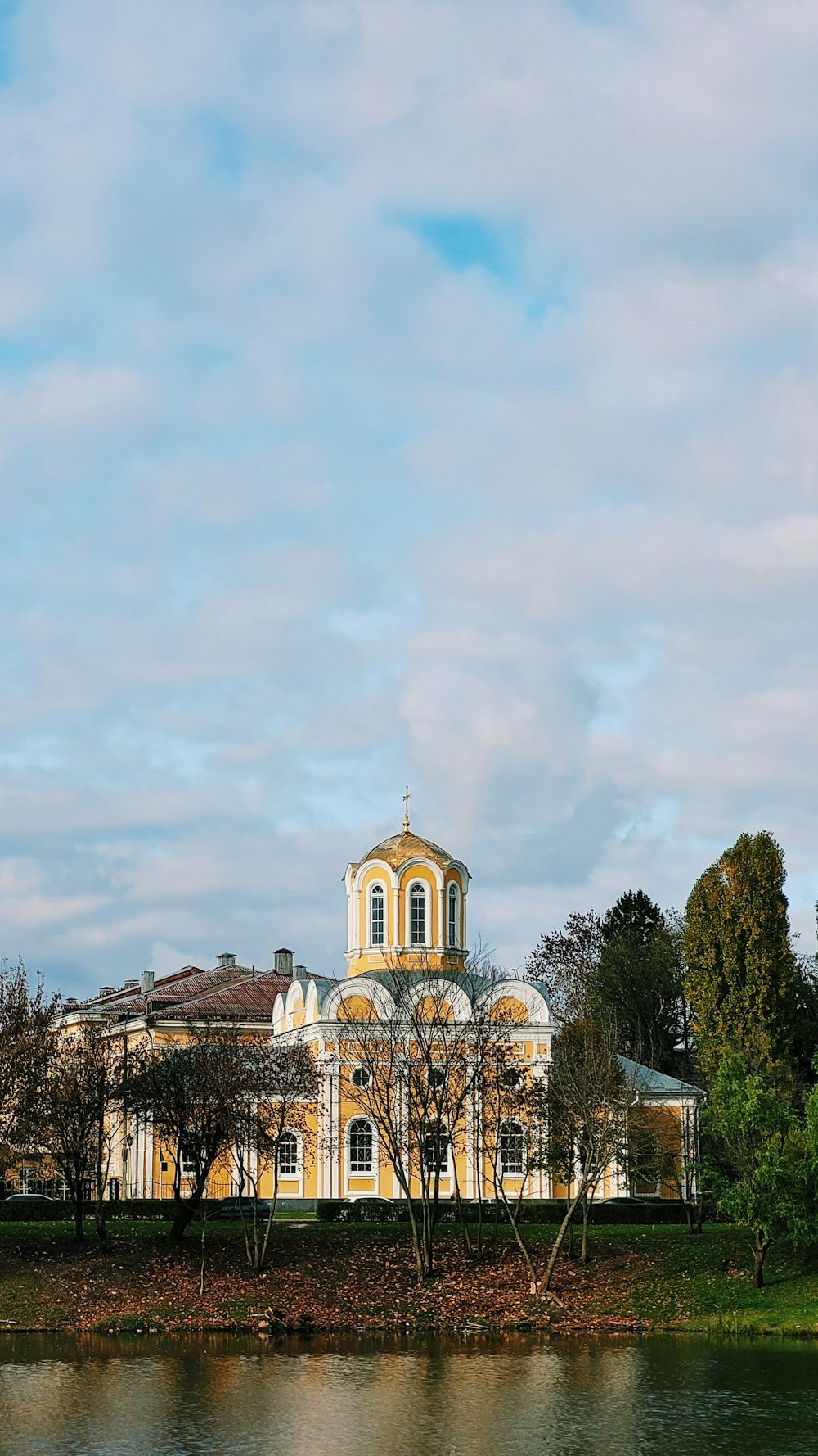 un bâtiment avec une tour et un plan d’eau devant lui