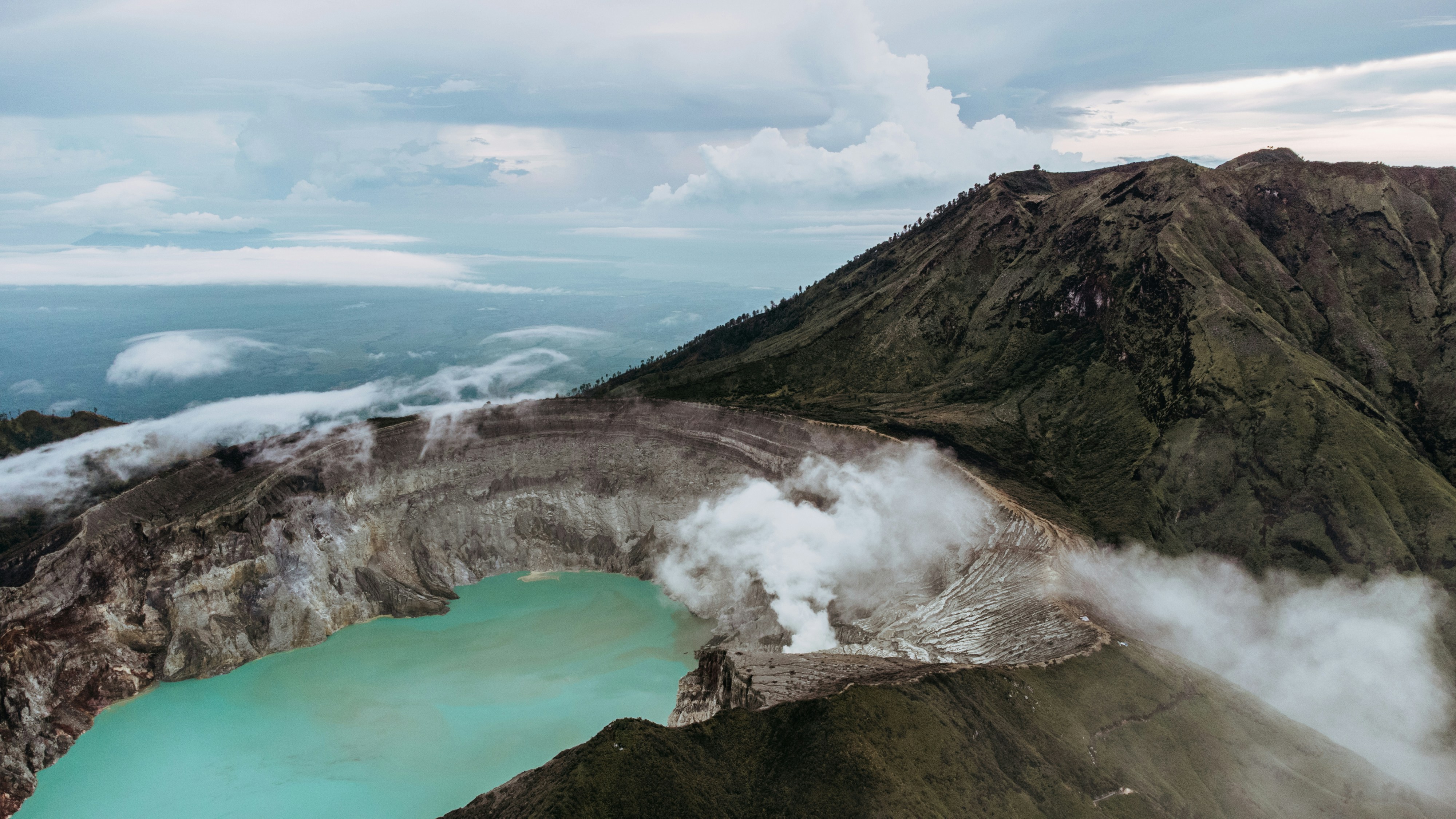 a rocky cliff with a body of water below