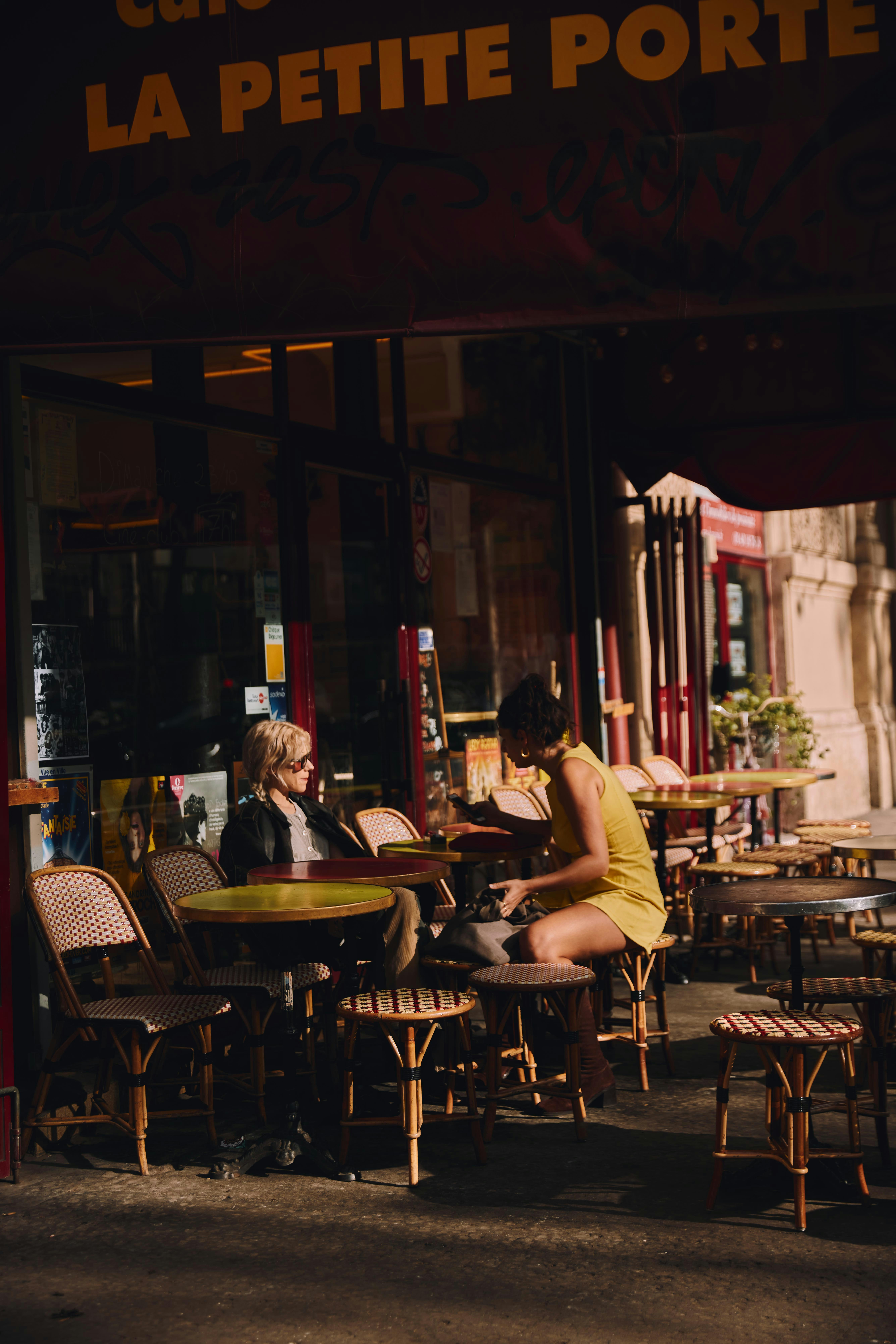 a couple of people sitting at a table outside a restaurant