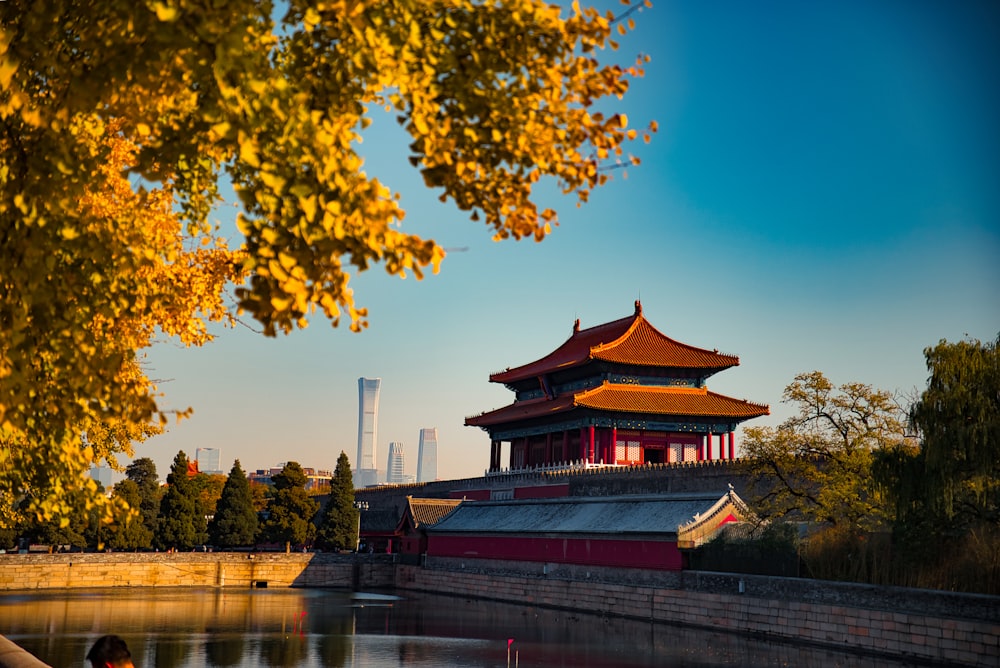 a building with a red roof by a body of water