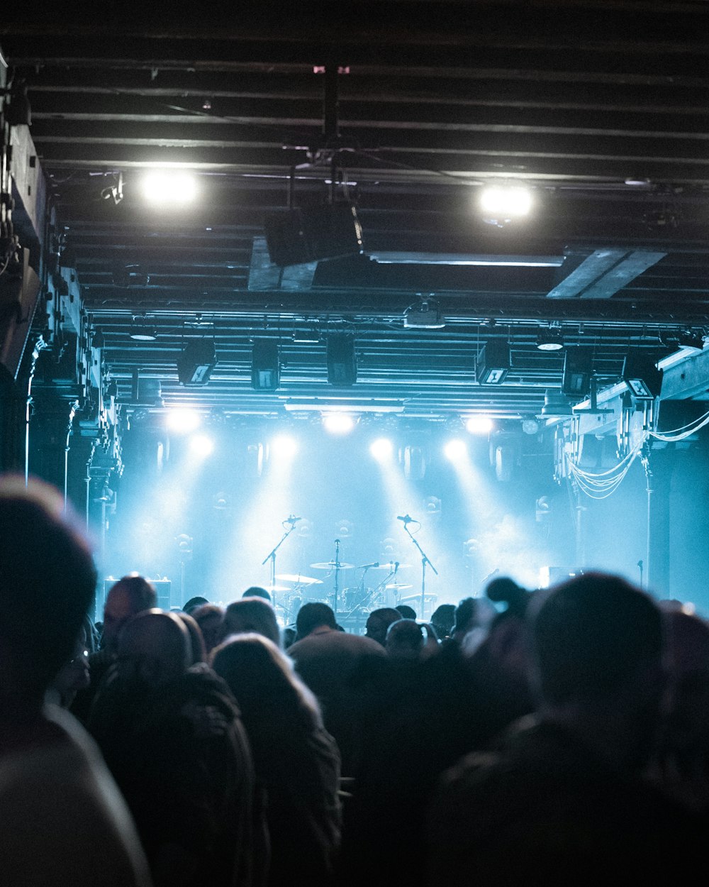 a crowd of people in front of a stage with lights