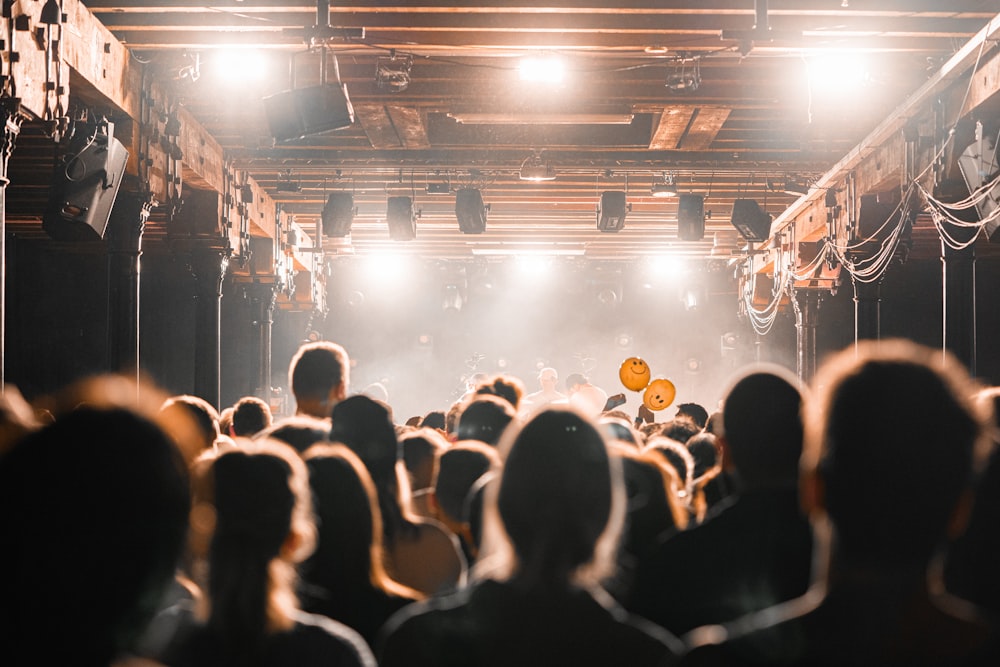 a crowd of people in a room with a stage and a stage