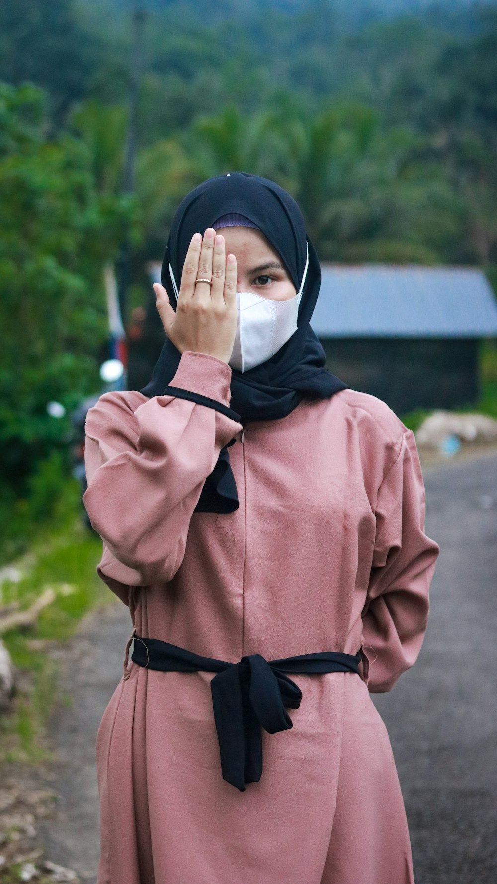 a person wearing a head scarf and holding the face up