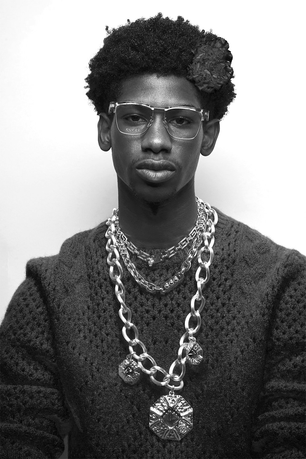 a man wearing glasses and a necklace